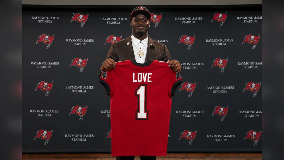 Jeremiyah Love holding a Buccaneers jersey